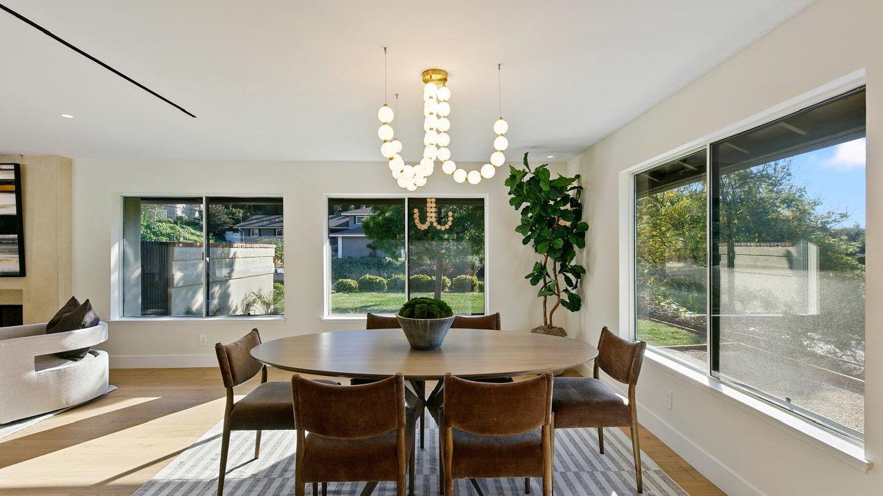 Dining room of a finished home with tall windows onto the garden