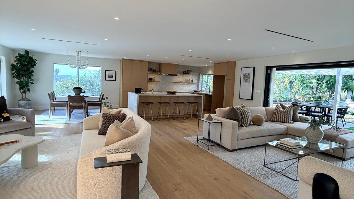 Open living room and kitchen of a finished home, doors open to the garden
